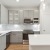 Light Gray Cabinets with White Quartz Countertops and Marble-Inspired Tile Backsplash