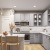 Light Gray Cabinets with White Quartz Countertops and Marble-Inspired Tile Backsplash